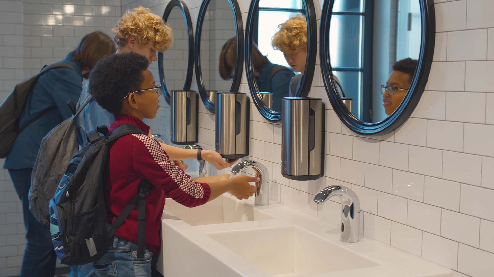 Kids washing their hands in a modern school bathroom